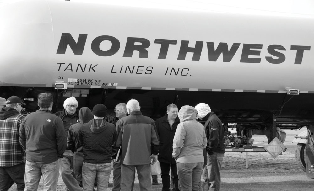Group talking before a northwest tanklines tank truck